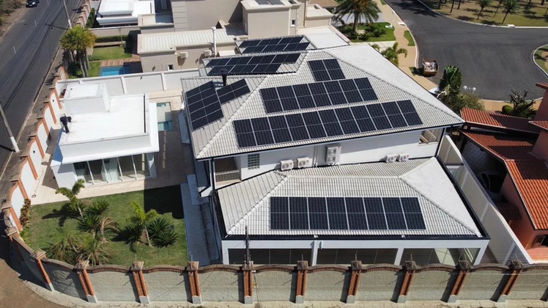 Vista aérea de residência com sistema de painéis solares instalado no telhado pela Rigo Instalações