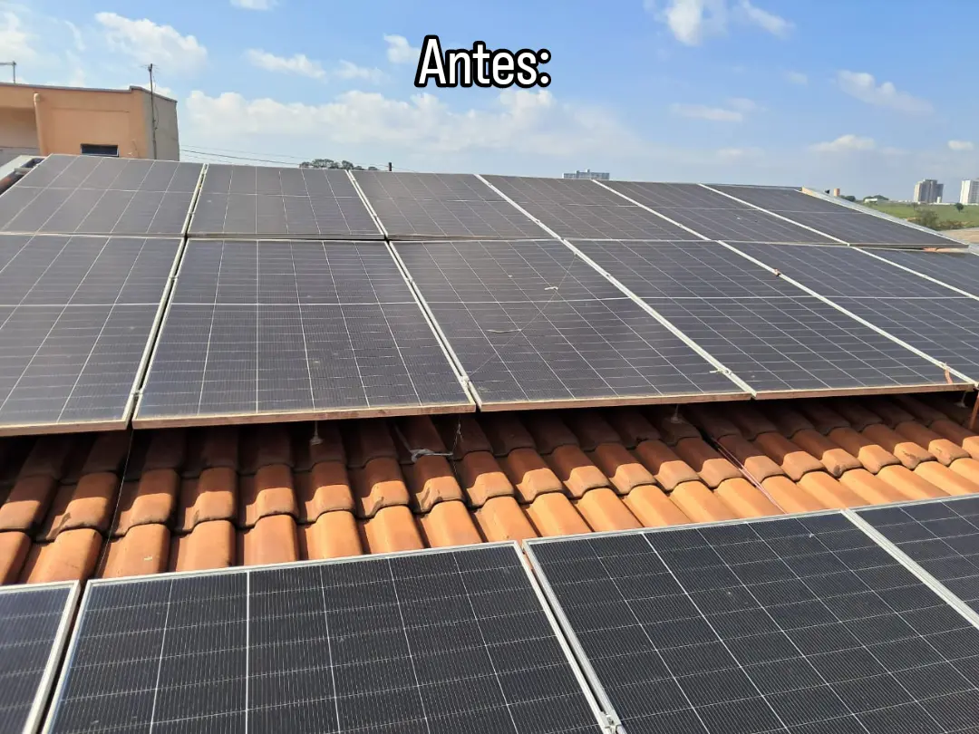 Fileiras de painéis solares sobre telhado cerâmico com vegetação ao redor